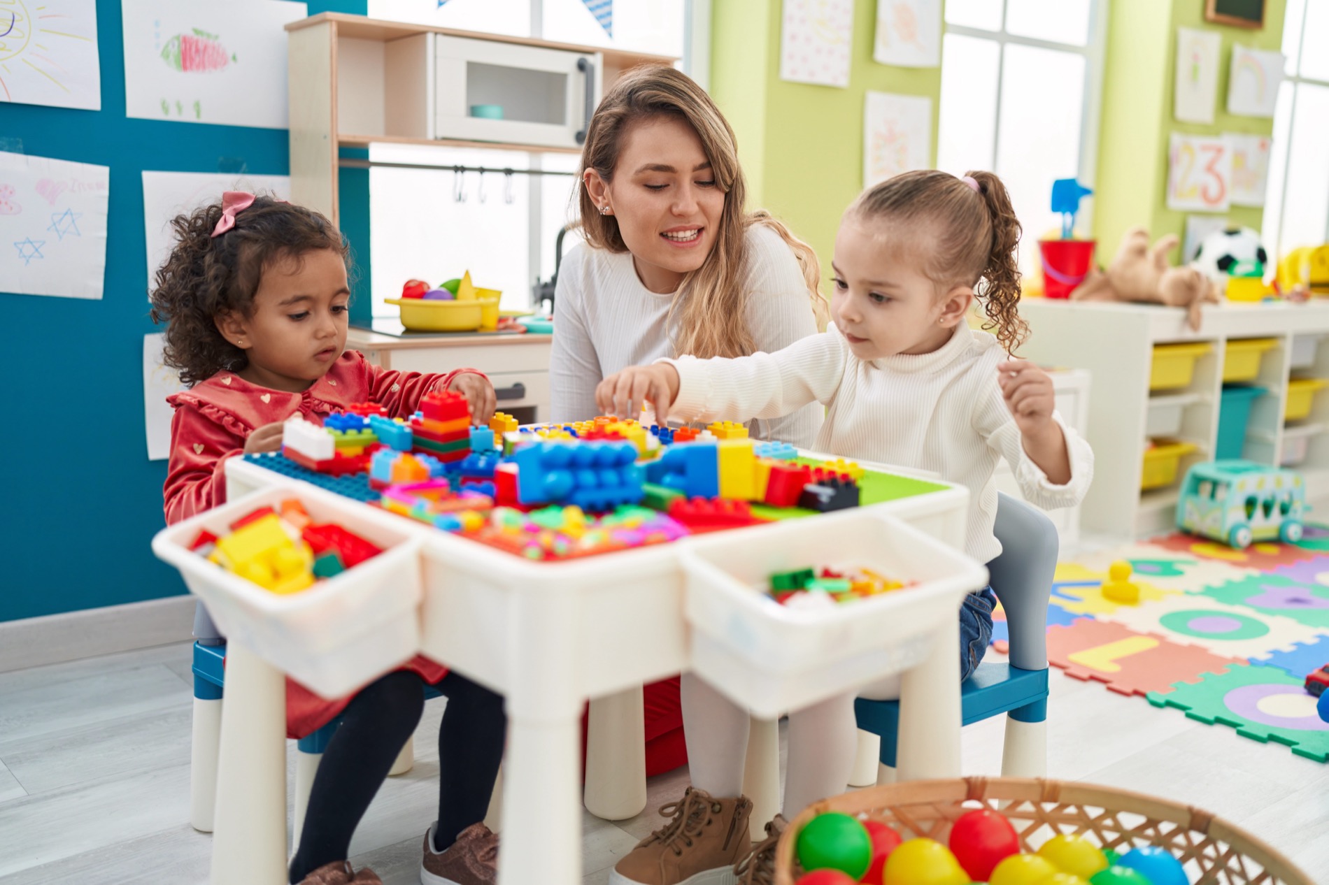 Teacher and young children playing in early-childhood class
